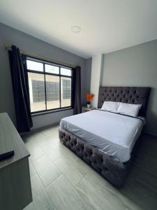 a bedroom with a large bed with a large window at Departamento exclusivo en salinas in Salinas