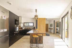 Una cocina con una mesa y algunas sillas. en Maison des Fleurs, en Vedène