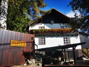 una casa blanca con flores en el techo y una valla en Drevenica Spanka en Špania Dolina