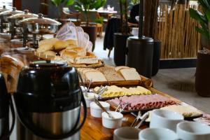 uma mesa coberta com muito pão e queijo em Art Green Teresópolis em Teresópolis