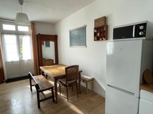 een keuken en eetkamer met een tafel en een koelkast bij Cosy Giverny in Giverny