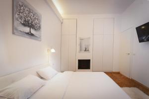 a white bedroom with a bed and a fireplace at Rozelor Accommodation in Timişoara
