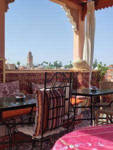 a patio with tables and chairs on a balcony at Riad Zahri in Marrakesh