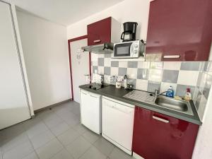 eine kleine Küche mit einer Spüle und einer Mikrowelle in der Unterkunft 2950-Appartement 4 pers avec piscine in Argelès-sur-Mer