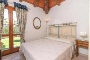 1 dormitorio con cama y ventana en Villa Viola, en San Teodoro