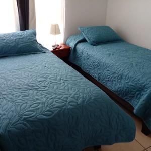 dos camas sentadas una al lado de la otra en un dormitorio en Marina Sol 310, en Coquimbo