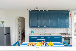 a kitchen with blue cabinets and a table with fruit on it at Villa Fanella, independent house between Sorrento & Amalfi in Piano di Sorrento