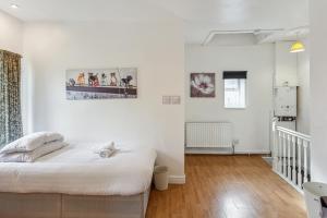 1 dormitorio blanco con 1 cama y escalera en Contractors & Pets Welcome - Sleeps 1-4, less than 1 mile from M606, Ideal for Longer Stays, en Cleckheaton