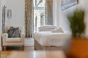 1 dormitorio con 1 cama, 1 silla y 1 ventana en Contractors & Pets Welcome - Sleeps 1-4, less than 1 mile from M606, Ideal for Longer Stays, en Cleckheaton