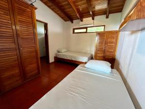 Habitación pequeña con 2 camas y ventana en Sweet Jungle Beach, en Bejuco