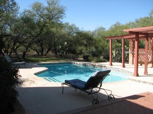 a chair sitting in front of a swimming pool at Desert Trails Bed & Breakfast in Tucson