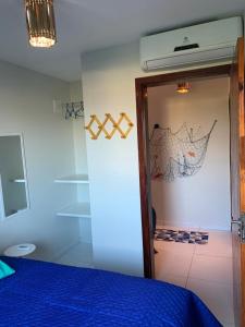 a bedroom with a blue bed and a door at Aconchego do francês - Praia do Francês - Alagoas/Maceio in Marechal Deodoro