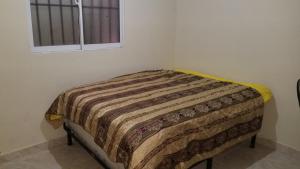 - un lit dans un coin d'une chambre avec fenêtre dans l'établissement Apartamentos JuanSabeloTodo, à Santiago de los Caballeros