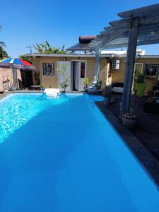 a swimming pool in front of a house at Tranquillité in Saint-Joseph