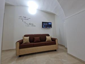 a brown couch in a room with a wall at Daniel's House in Catania