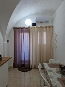 a kitchen with a table and curtains in a room at Daniel's House in Catania