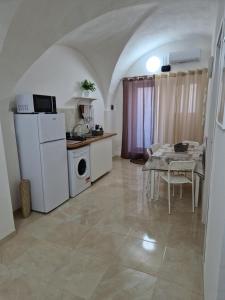 a kitchen with a table and a white refrigerator at Daniel's House in Catania