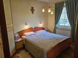 ein Schlafzimmer mit einem Bett und einem Kreuz an der Wand in der Unterkunft apartment AURORA in Rogaška Slatina