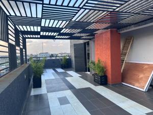 a rooftop patio with a black and white pergola at COC00N by IVY in Lagos
