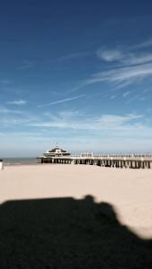 um cais numa praia com o oceano ao fundo em Dune Du Clémot em Blankenberge