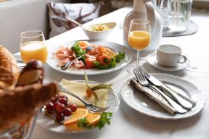 einen Tisch mit Teller mit Lebensmitteln und Gläsern Orangensaft in der Unterkunft Gasthaus Schneider in Bad Bocklet