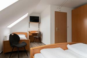 a bedroom with two beds and a desk and a chair at Gasthaus Schneider in Bad Bocklet