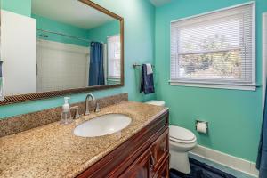 a bathroom with a sink and a toilet and a mirror at Centrally Located Spacious Abode in Charlotte +23 photos