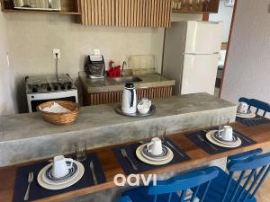 uma cozinha com uma mesa com pratos e utensílios em Qavi - Excelente casa com piscina privativa #Lambari06 em São Miguel dos Milagres