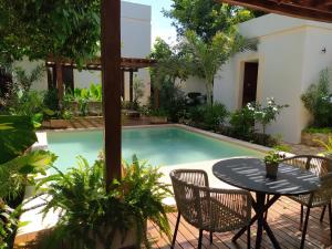 ein kleines Schwimmbecken mit Tisch und Stühlen in der Unterkunft Hotel Sutuk in Valladolid