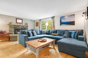 een woonkamer met een blauwe bank en een tafel bij Whites Hill Ski Retreat in Dover
