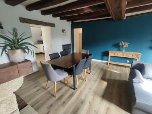 a dining room with a table and chairs and a couch at Maison de campagne 