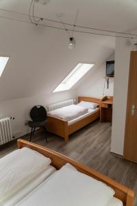 sypialnia z 2 łóżkami, biurkiem i świetlikiem w obiekcie Gasthaus Schneider w mieście Bad Bocklet
