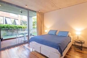 een slaapkamer met een bed en een groot raam bij Be House & Spa by Oceana Suites in Punta del Este
