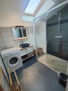 a bathroom with a washing machine and a shower at Maison de campagne 