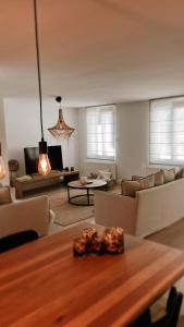 a living room with couches and a table at Dune Du Clémot in Blankenberge