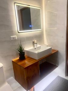 a bathroom with a white sink and a mirror at Lucia’s Place in Tanauan