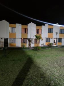 a building at night with a green field in front of it at Casa amoblada Dosquebradas in Dosquebradas
