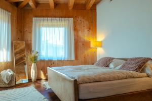 a bedroom with a large bed with a window at Strohlehm'zhaus in Weiden am See