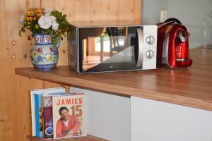 a microwave sitting on a shelf next to a magazine at Strohlehm'zhaus in Weiden am See