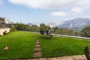a garden with a chair and a view of mountains at Villa Fanella, between Sorrento & Amalfi in Piano di Sorrento
