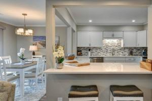 cocina y comedor con armarios blancos y mesa en Beachwalk 171 en Hilton Head Island