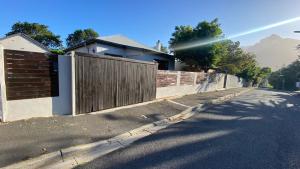 a house with a fence on the side of a street at Studio Flatlet on Montreal in Cape Town