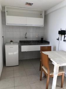 cocina con mesa y encimera blanca en 1702 Suite Vista Mar - Golden Tower, en Natal