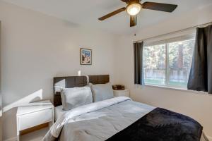 a bedroom with a bed with a ceiling fan and a window at Cozy Lake Tahoe Home with Yard, Near Ski Resorts! in South Lake Tahoe