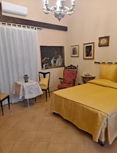 una camera con letto, tavolo e lampadario a braccio di bed and breakfast Grotta dell'Olio a Sarno