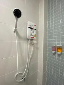um chuveiro com secador de cabelo na casa de banho em โฮมสเตย์ สุขสำราญ รีสอร์ท 