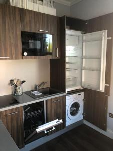 a kitchen with a washing machine and a microwave at Studio Flat in London