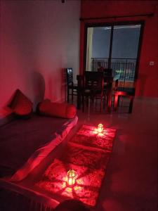 a red room with a bed with two candles on the floor at Tani s Homestay in Bāruipur