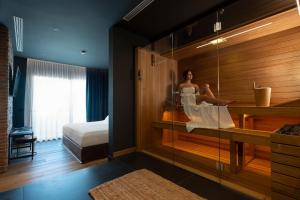 a woman sitting in a sauna in a hotel room at Savoy Beach Hotel & Thermal Spa in Bibione