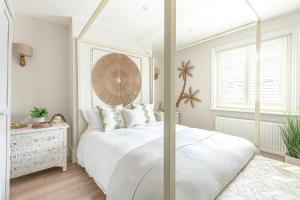 Un dormitorio con una cama blanca y una ventana. en The Shell House (Sleeps 12 - 5 mins to Beach), en Bournemouth